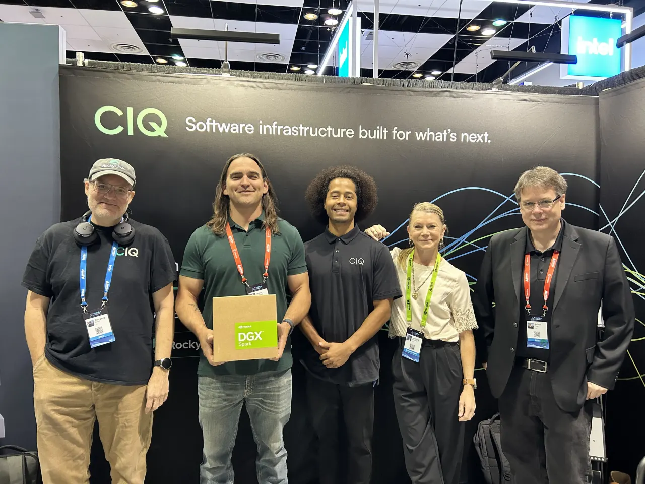 Five members of the CIQ team at the AI Infra Summit booth, one holding an NVIDIA DGX Spark box