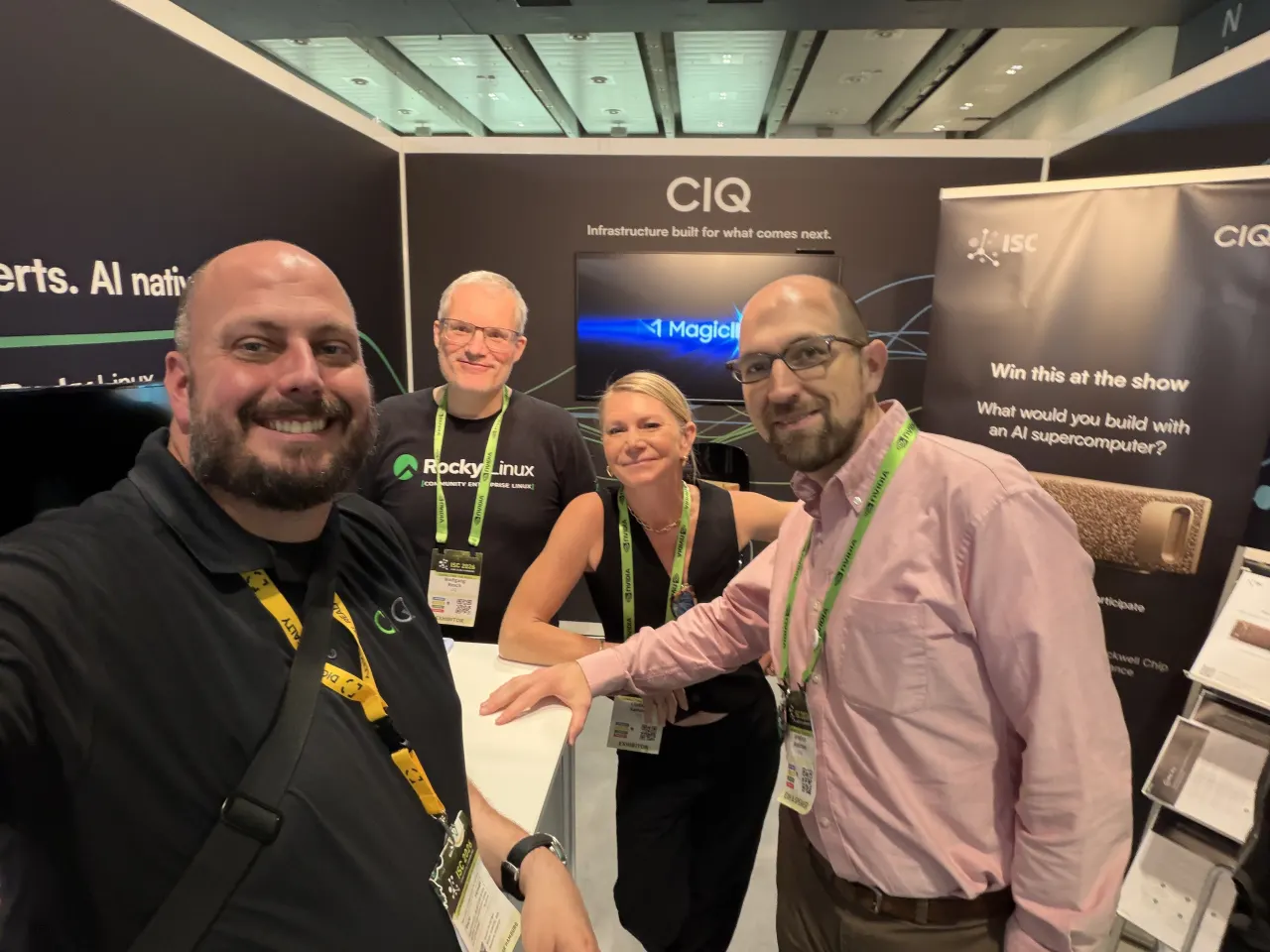 Four CIQ team members smiling for a selfie inside the CIQ booth